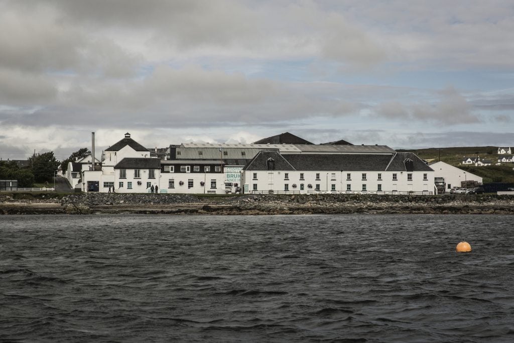 The Bruichladdich Distillery with the sea in front of it on a cloudy day on Islay