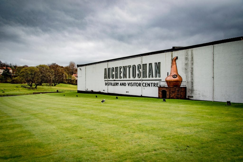 The outside of the Auchentoshan Distillery with a minature pot still