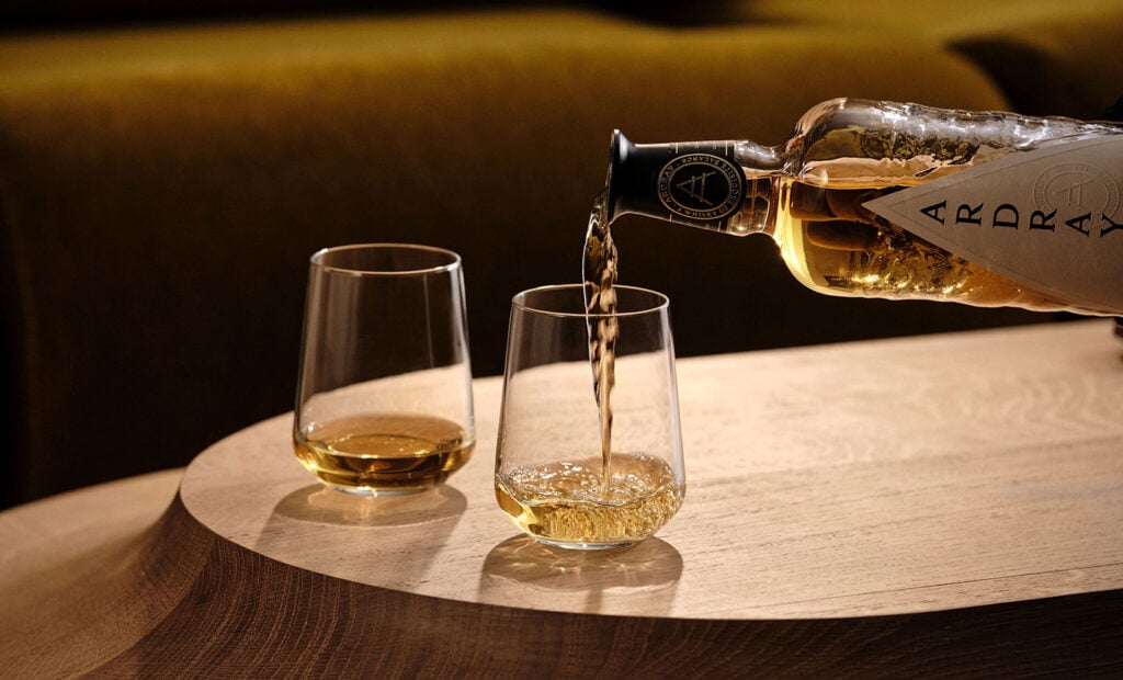 A bottle of Ardray blended Scotch whisky poured into two glasses
