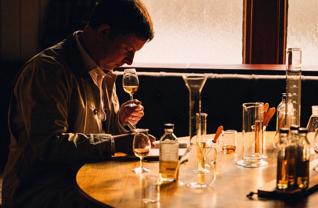 A blender samples whisky in a lab