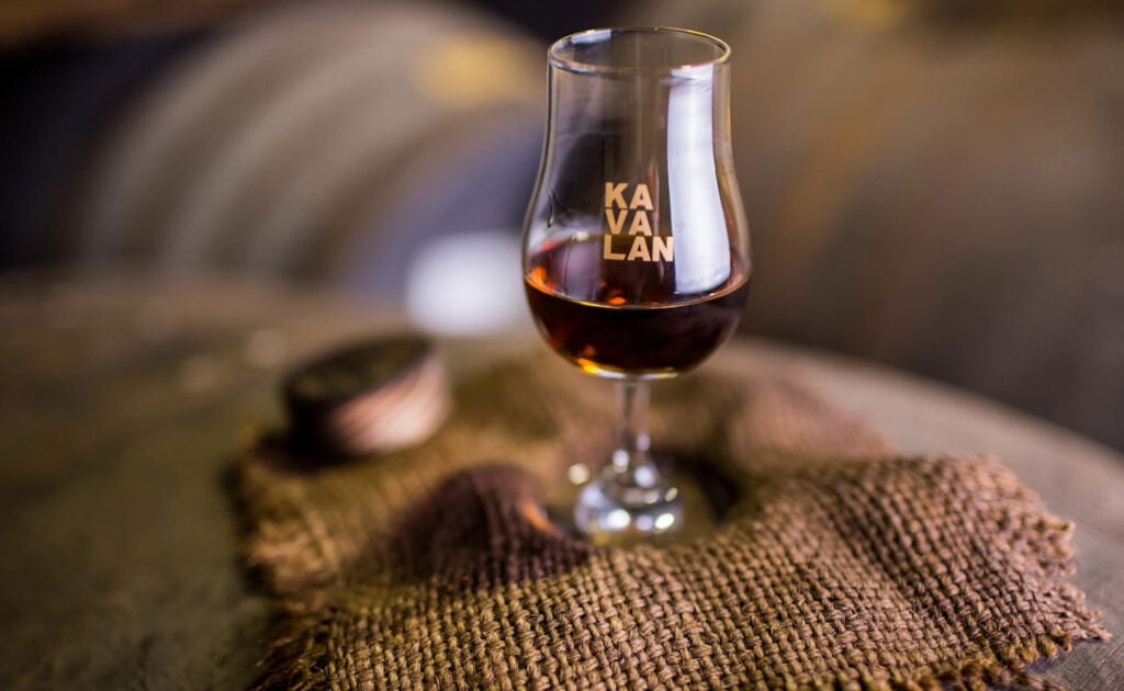 A glass of Kavalan Sherry Oak Whisky on a barrel of whisky, one of Master of Malt's Top 10 Sherried Whisky for 2026