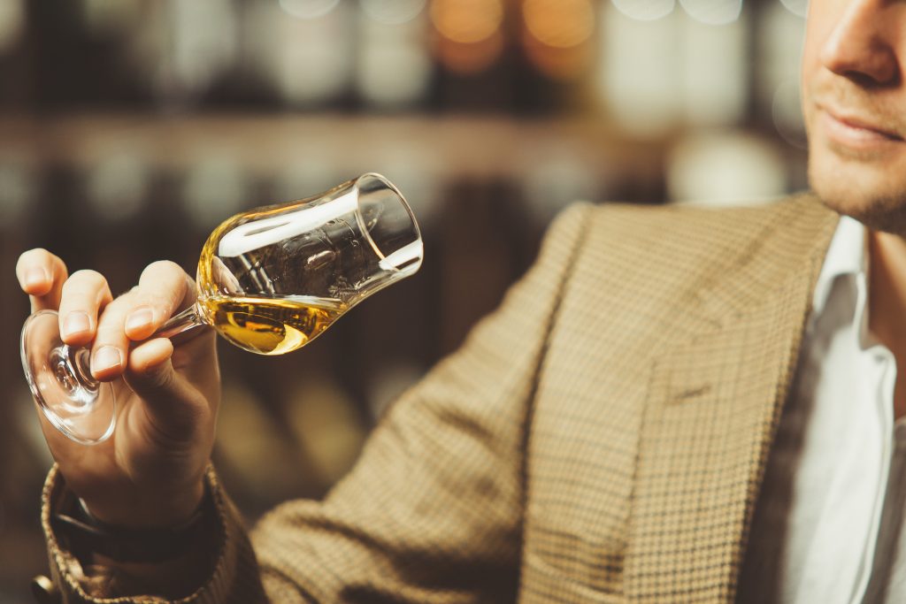 Man evaluating a glass of whisky