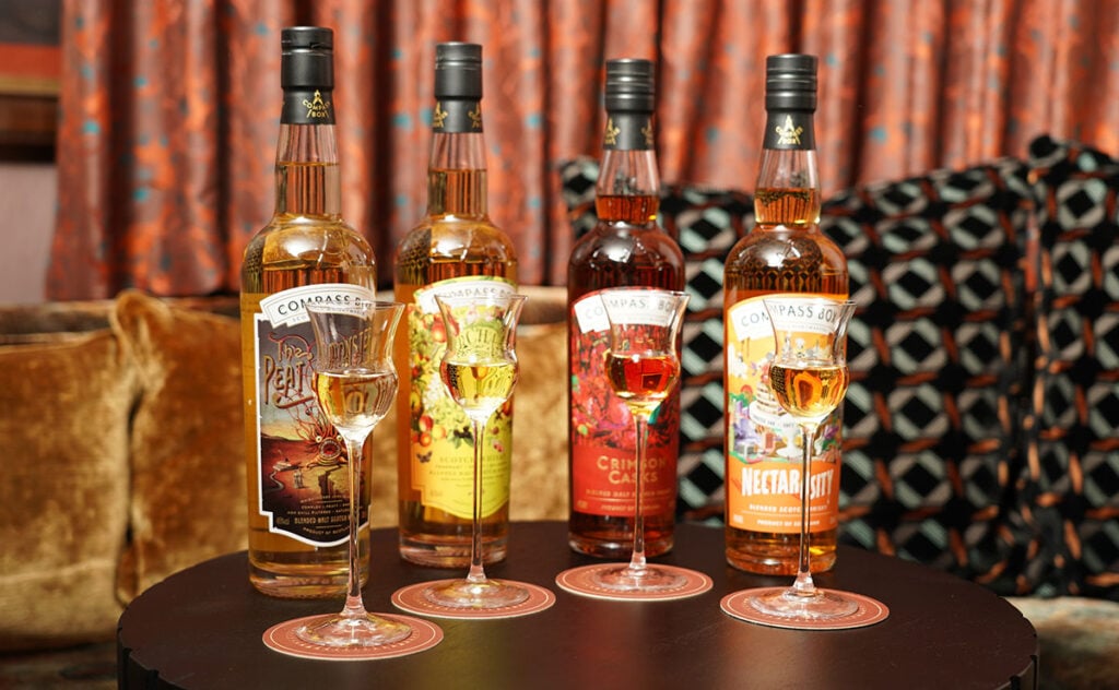 Archive & Myth's vertical tasting of all four core Compass Box expressions in tasting glasses with the full bottles behind them along with a miniature Melba Rob Roy cocktail