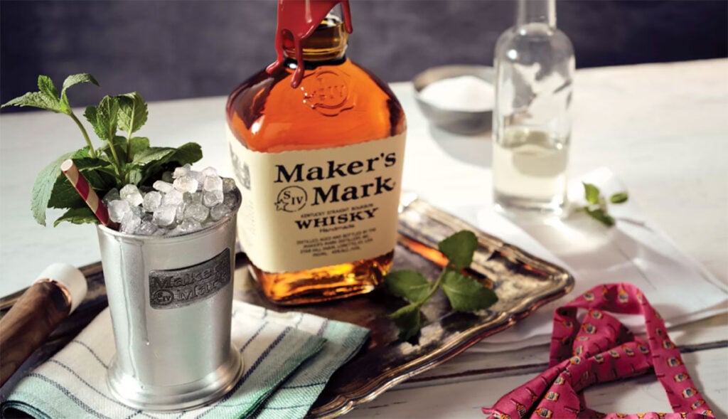 A bottle of Maker's Mark with a Mint Julep cocktail