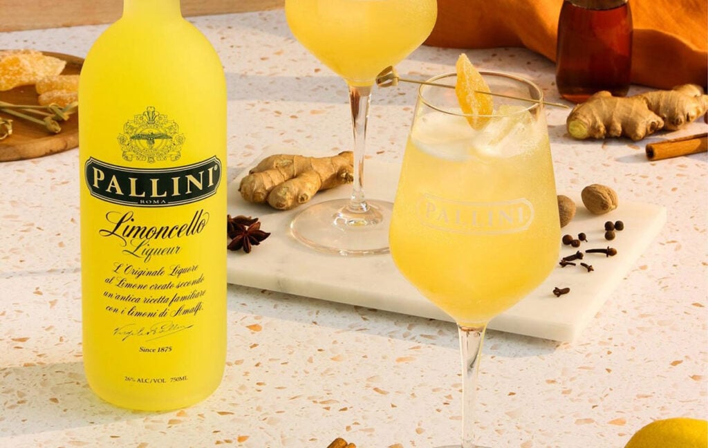 A glass of mocktail Spritz with a bottle of Pallini Limonzero