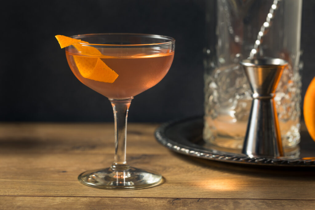 An El Presidente Cocktail with an Orange Garnish and cocktail equipment
