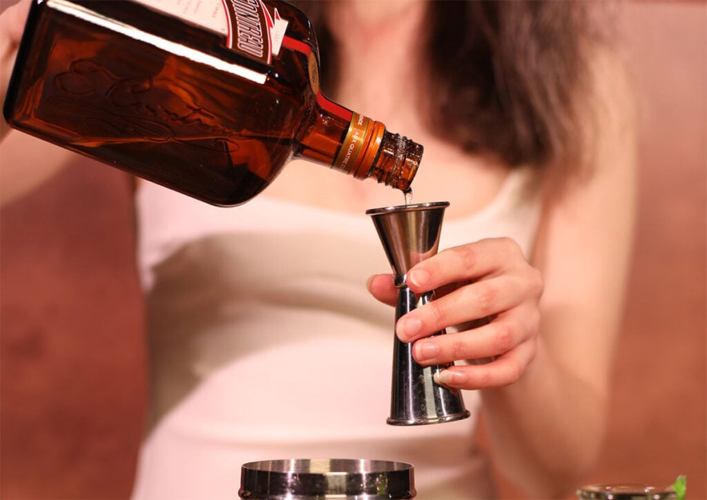 Adding a measure of Cointreau to Margarita