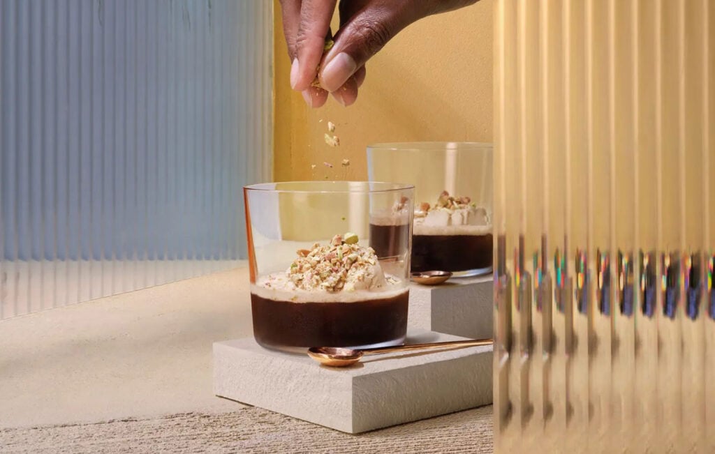 A man sprinkles a garnish on The Sweet & Nutty Affogato, a whisky cocktail from Johnnie Walker