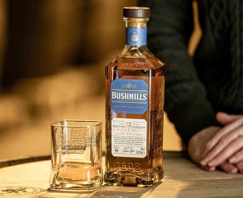 Bushmills 12 Year Old on a barrel with a glass of whiskey