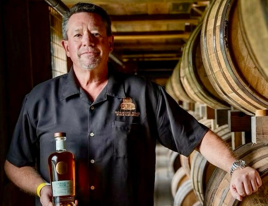 Mike Gilmore, founder of Roaming Road Spirits, in a warehouse with his whiskey