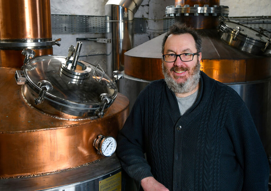 Retribution Distilling founder Richard Lock in front of the distillery's new stills