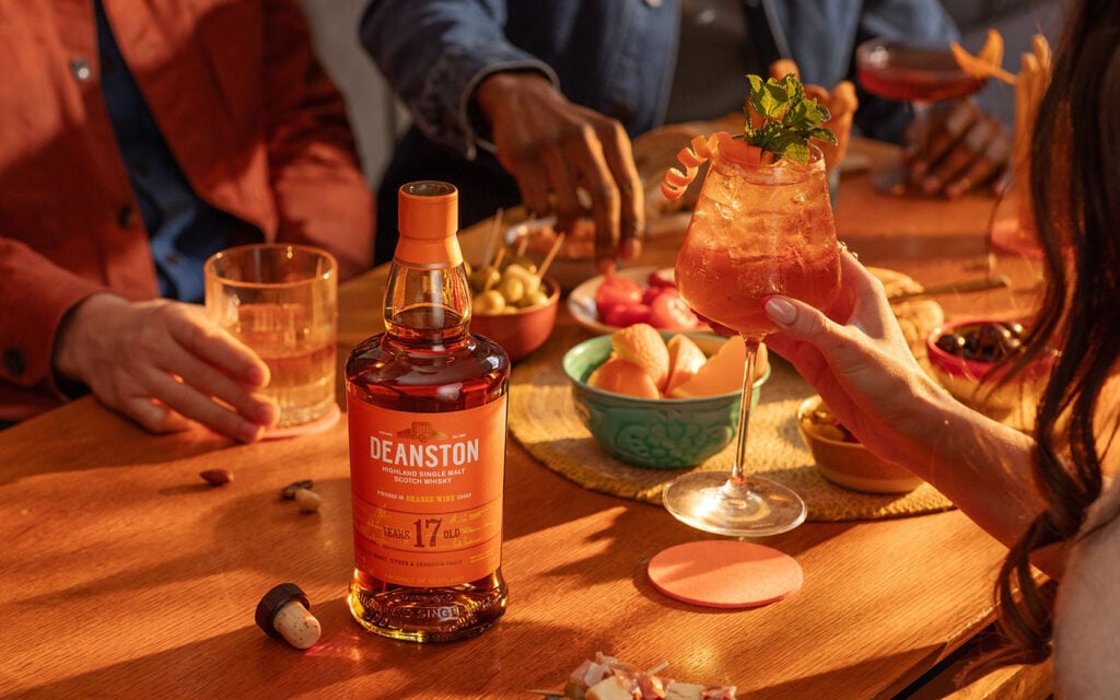 The Deanston Orange Wine Cask Orange Spritz on a table with Spanish cuisine