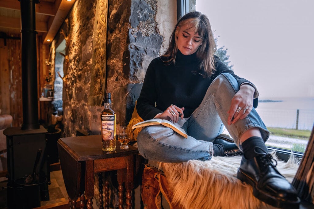 Poet Iona Lee sat in Skye with a bottle of Torabhiag Taigh