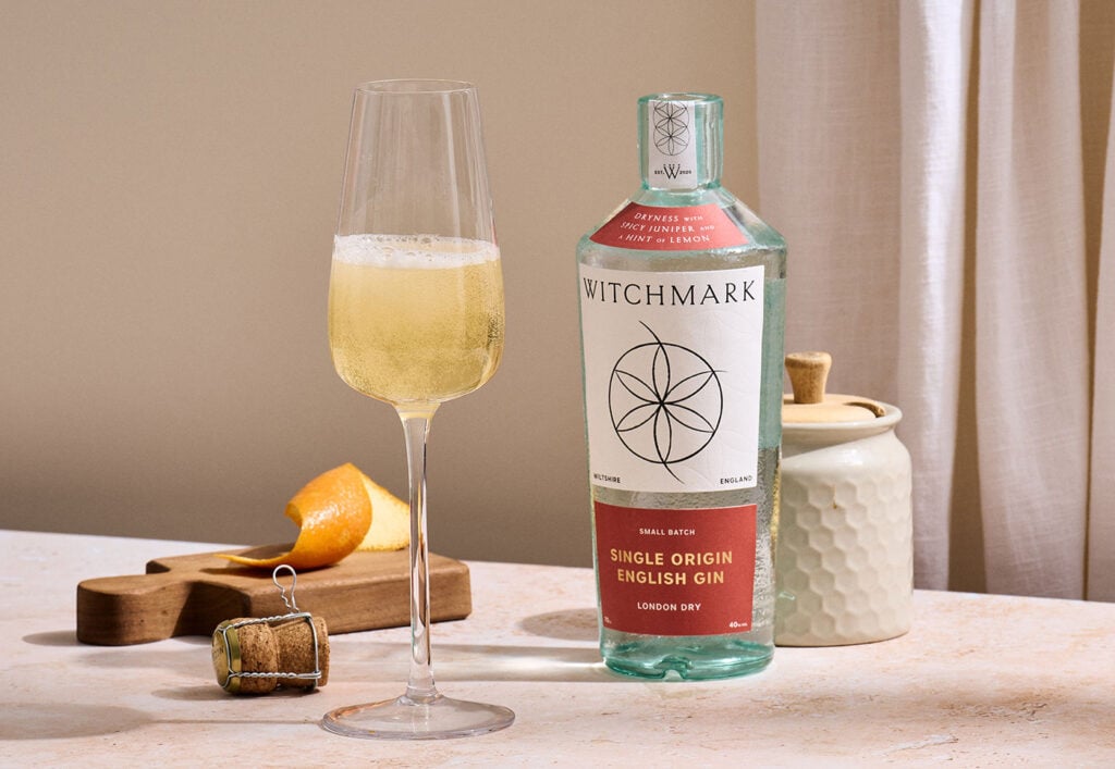 A bottle of Witchmark Single Origin London Dry Gin with a cocktail