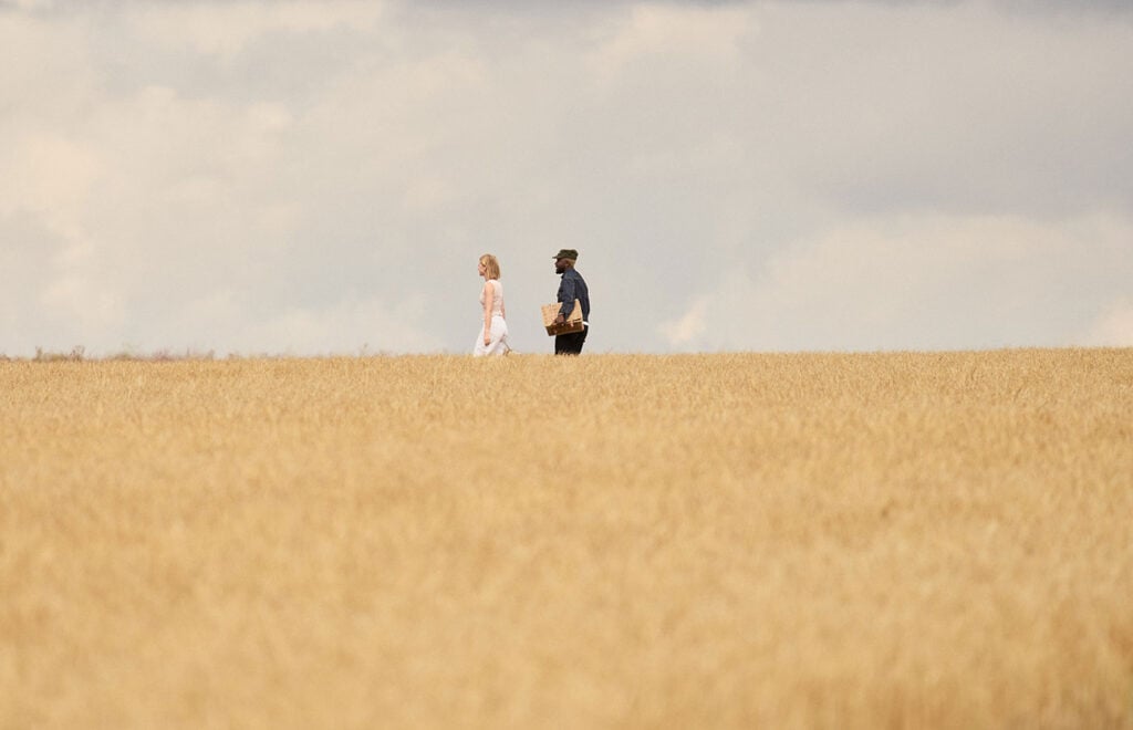 Witchmark Distillery employees walk through a barley field