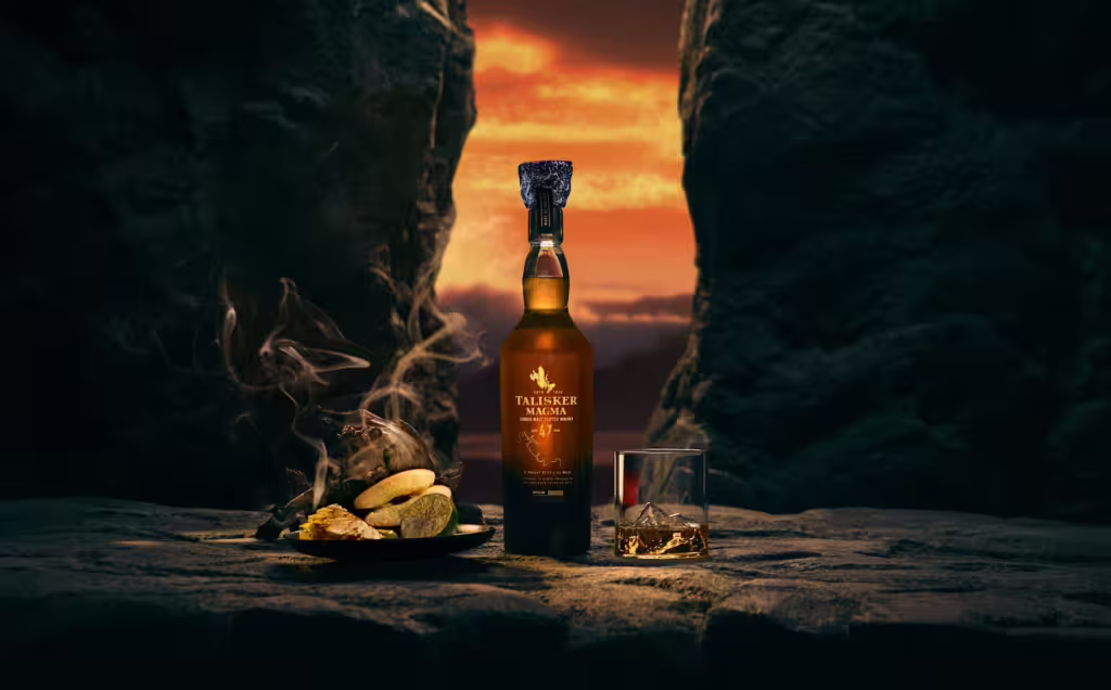 A lifestyle image of Talisker 47 Year Old Magma, pictured on the Isle of Skye at sunset with lemons and a glass of whisky
