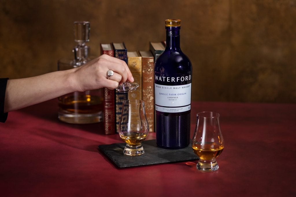 A bottle of Waterford whisky and whisky in a glass