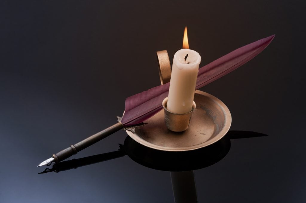 Quill pen next to candle