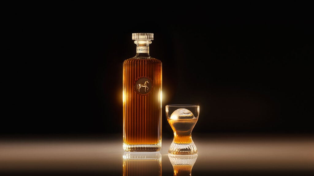 A bottle of SirDavis whisky with a glass filled with whisky and ice