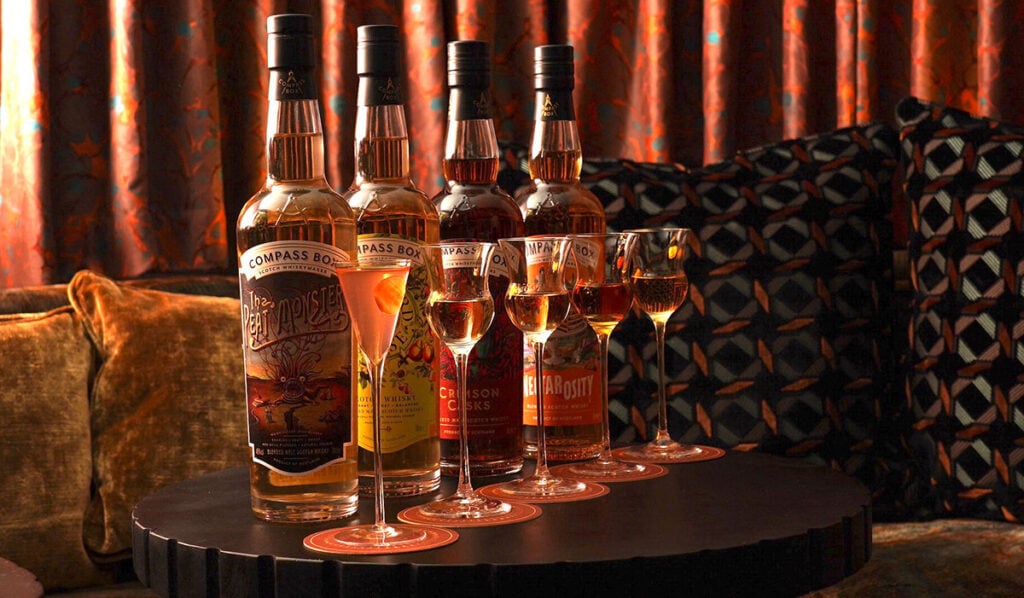 Archive & Myth's vertical tasting of all four core Compass Box expressions in tasting glasses with the full bottles behind them along with a miniature Melba Rob Roy cocktail