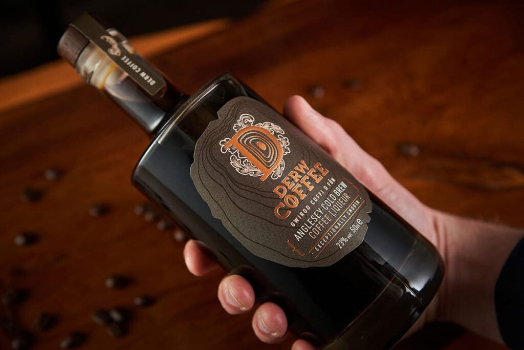 A hand holding a bottle of Derw Coffee Anglesey Cold Brew Coffee Liqueur