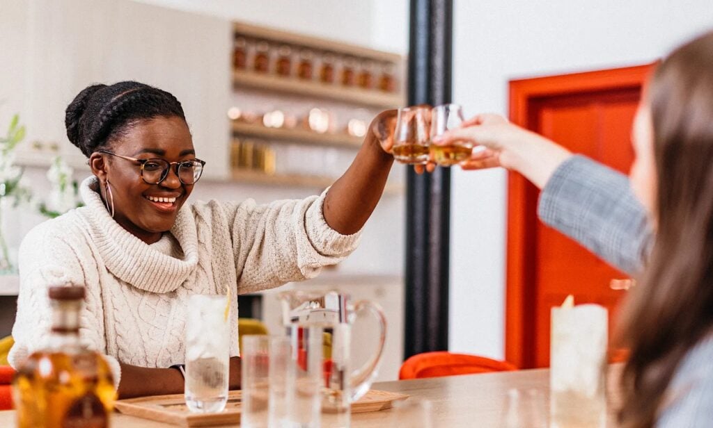 Two women cheers with a glass of whisky at the Cardhu Distillery