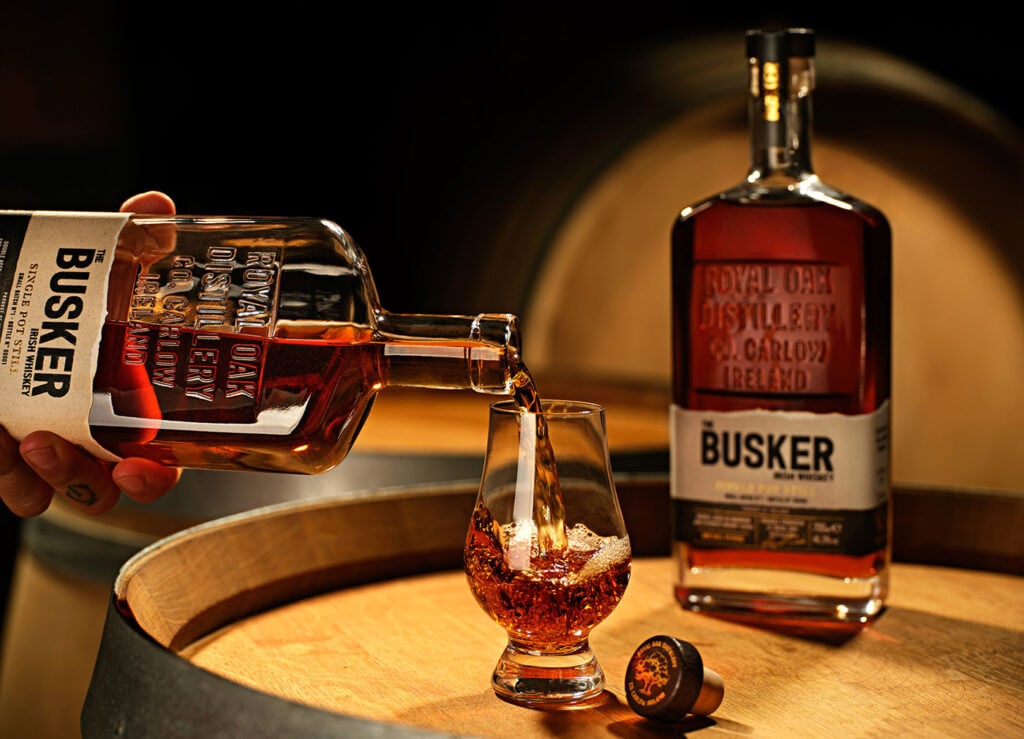 The Busker Pot Still Whiskey. pictured here being poured into a Glencairn glass on a cask