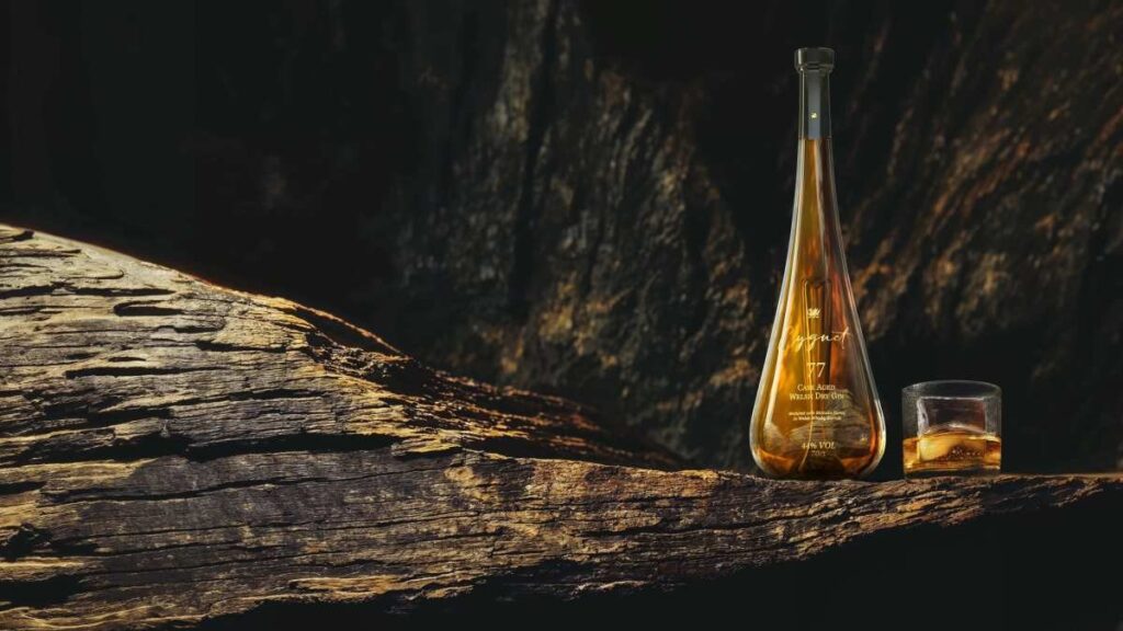 A bottle of Cygnet 77 Gin surrounded by luxurious wood